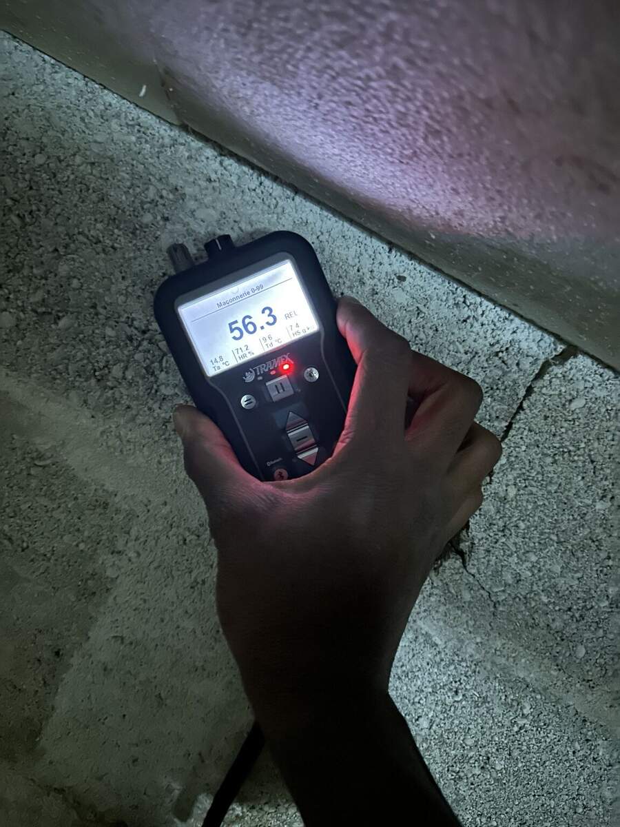 Mesure d'humidité au Tramex sur maçonnerie en sous-sol : valeur 56.3 REL confirmant une charge hydrique importante