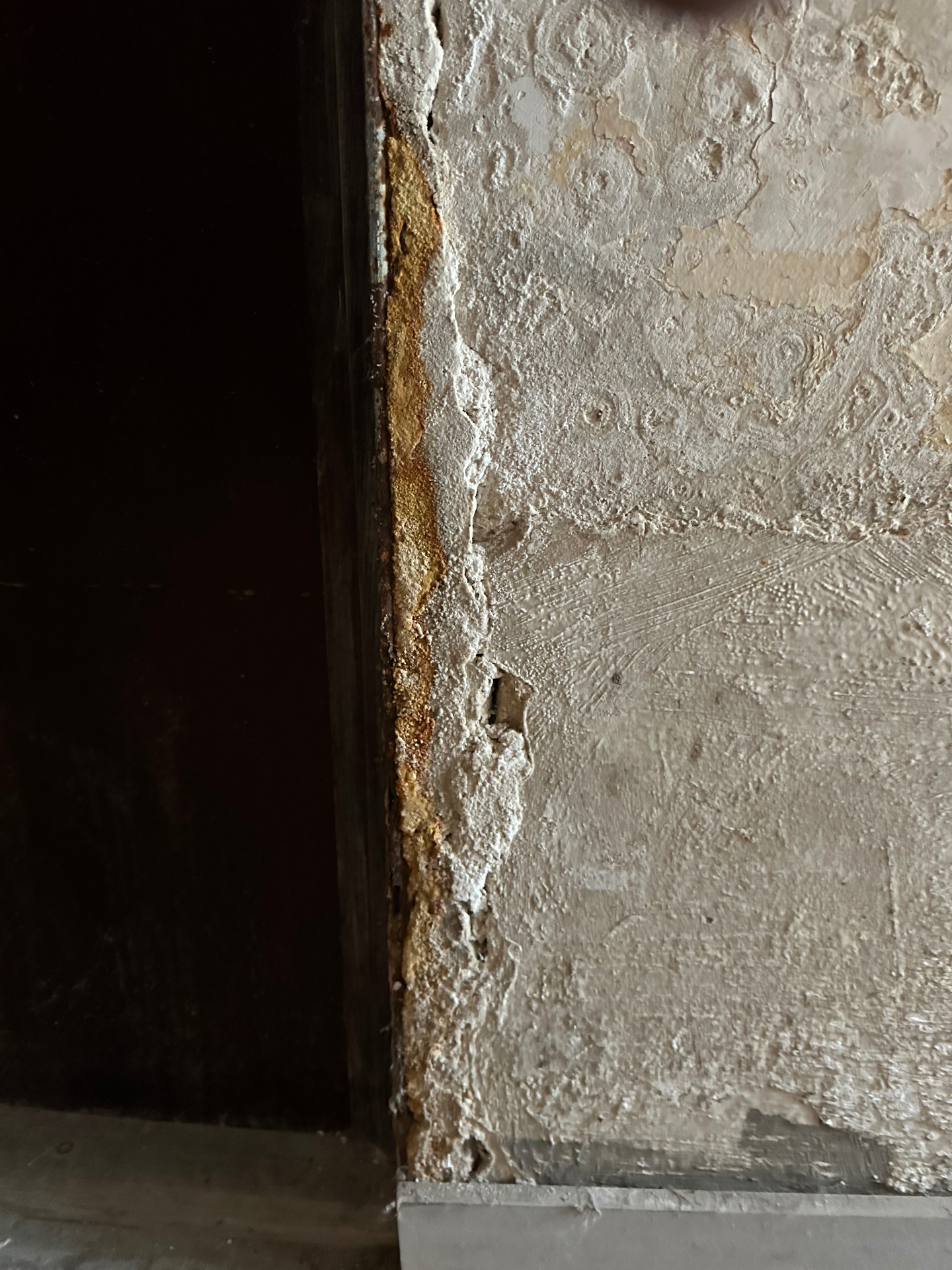 Dépôts blancs de salpêtre et efflorescences salines sur un mur de cave en pierre