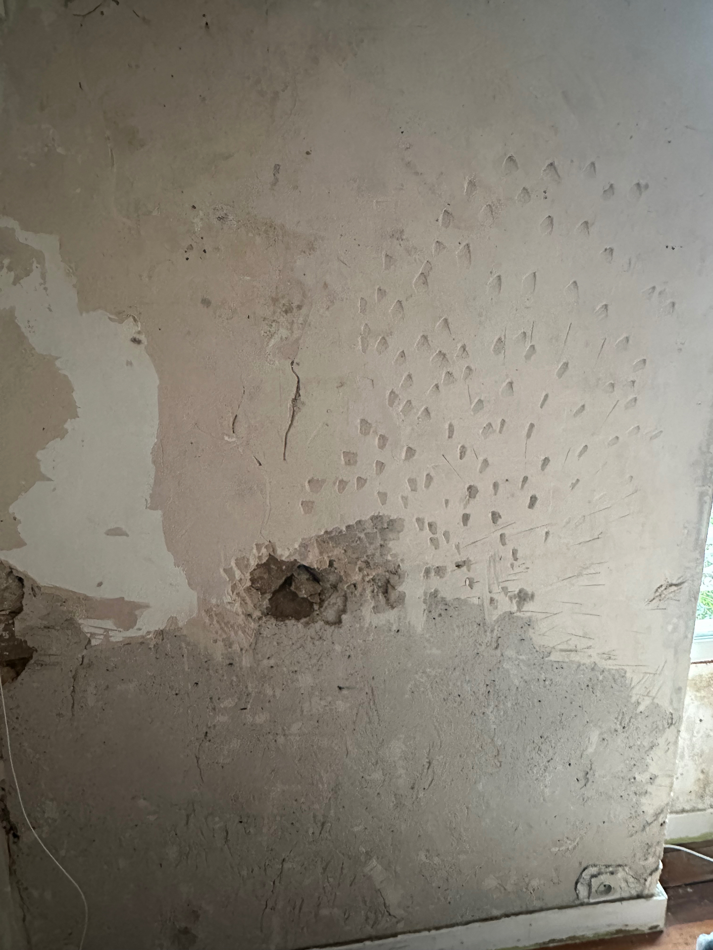 Taches brunes d'humidité avec traces de coulures sur un mur intérieur blanc